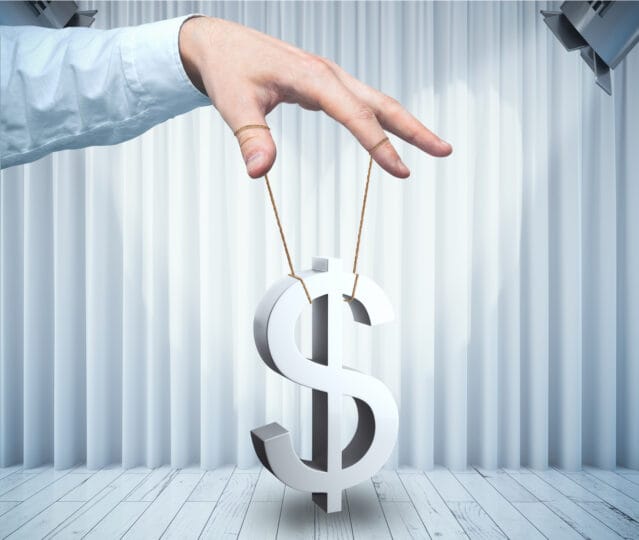 Man controlling dollar sign as puppet on white stage with curtains. Price manipulation concept